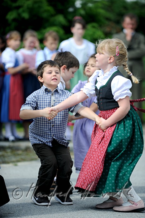 children dance around the maypole