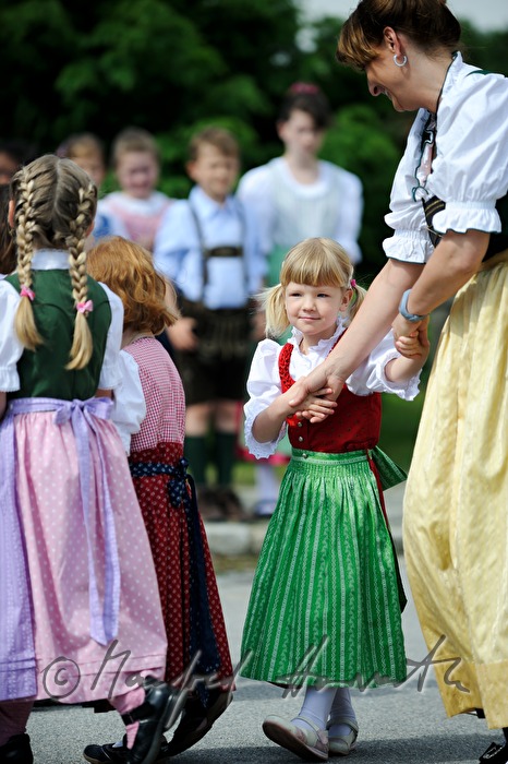 children dance around the maypole
