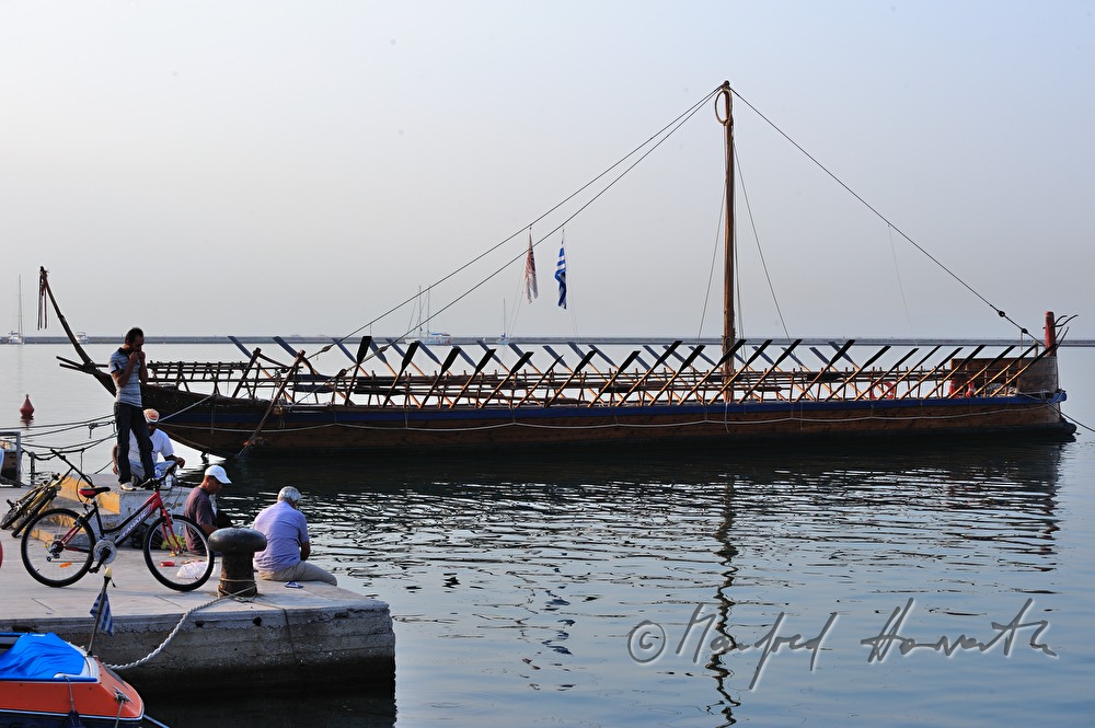 fishermen near a galley in the harbour