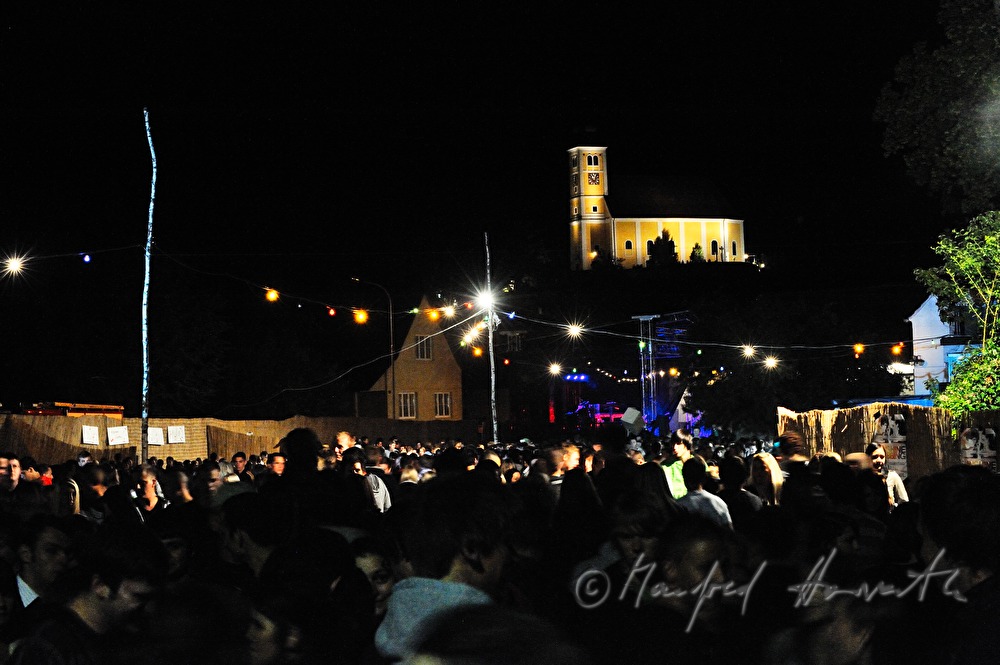 festival area with visitors at the foot of the church