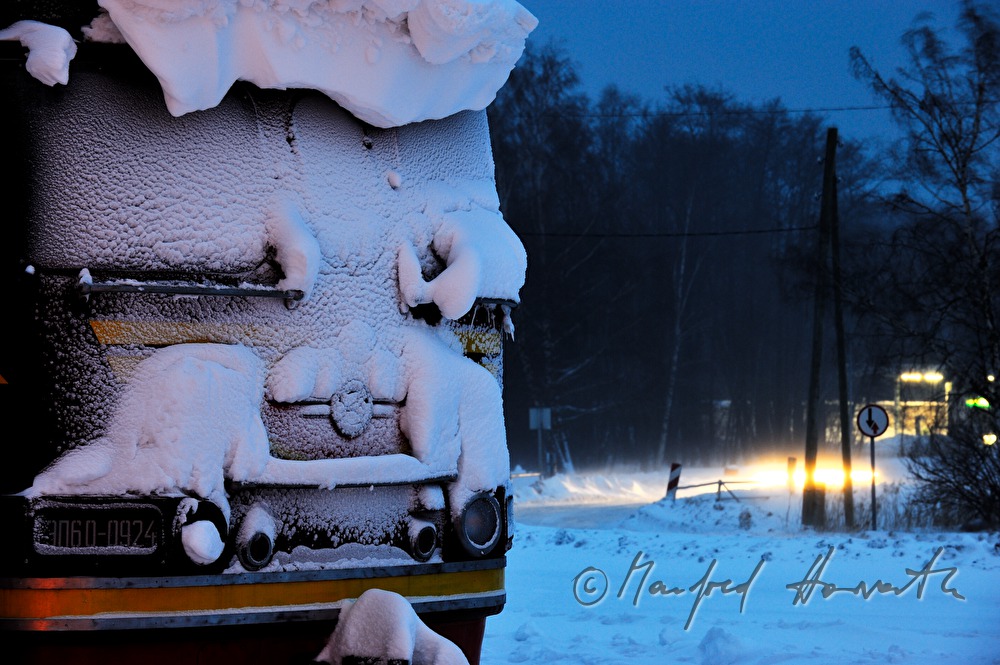 train stuck in the snow and light of a car