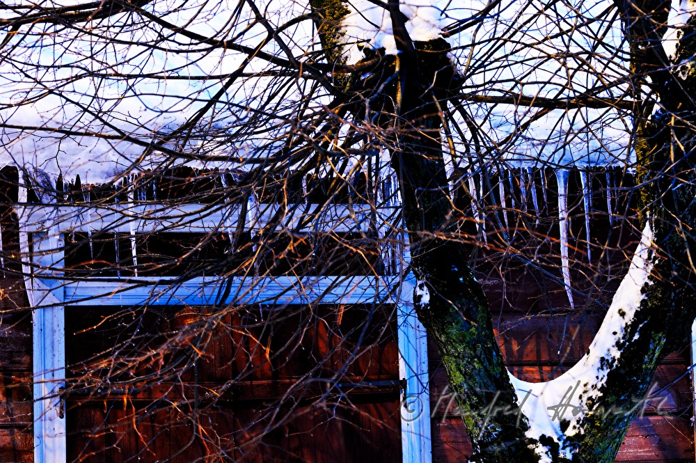 icicles on the roof of a wooden house