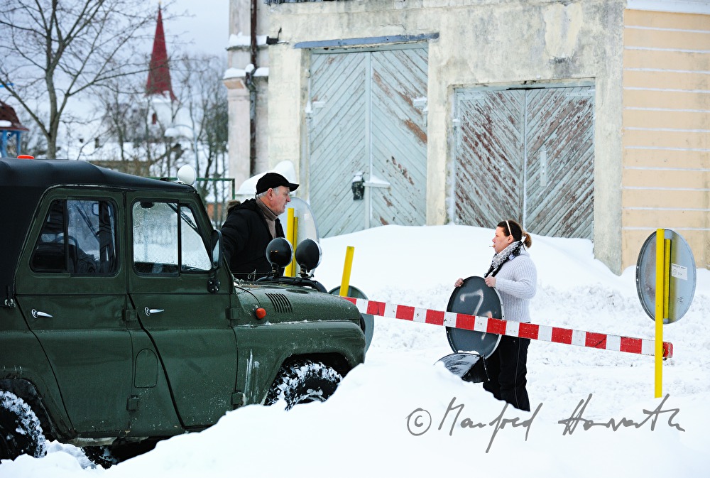 track marshal opens the barrier for an arrriving vehicle