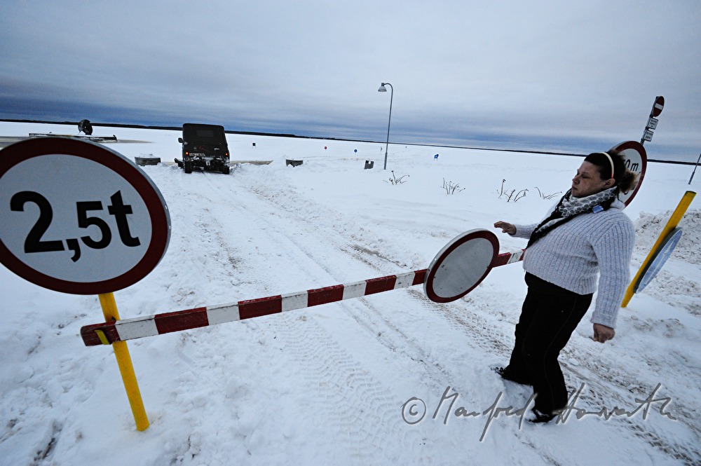 track marshal opens the barrier for an arrriving vehicle