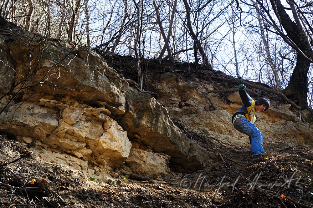 boy jumps from the edge of a sand pit