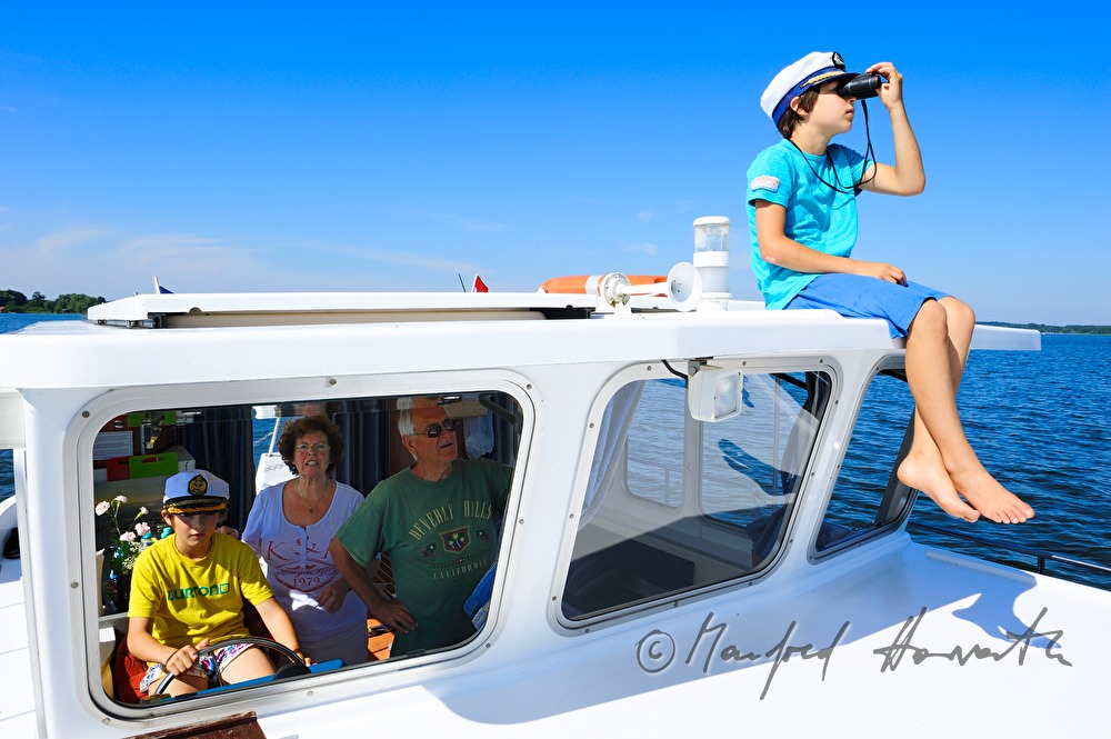 family steering a house boat