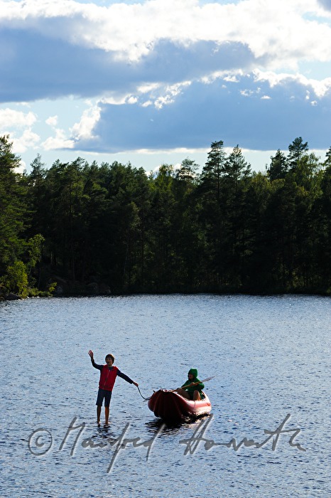 children with a kajak near a tiny island in the lake