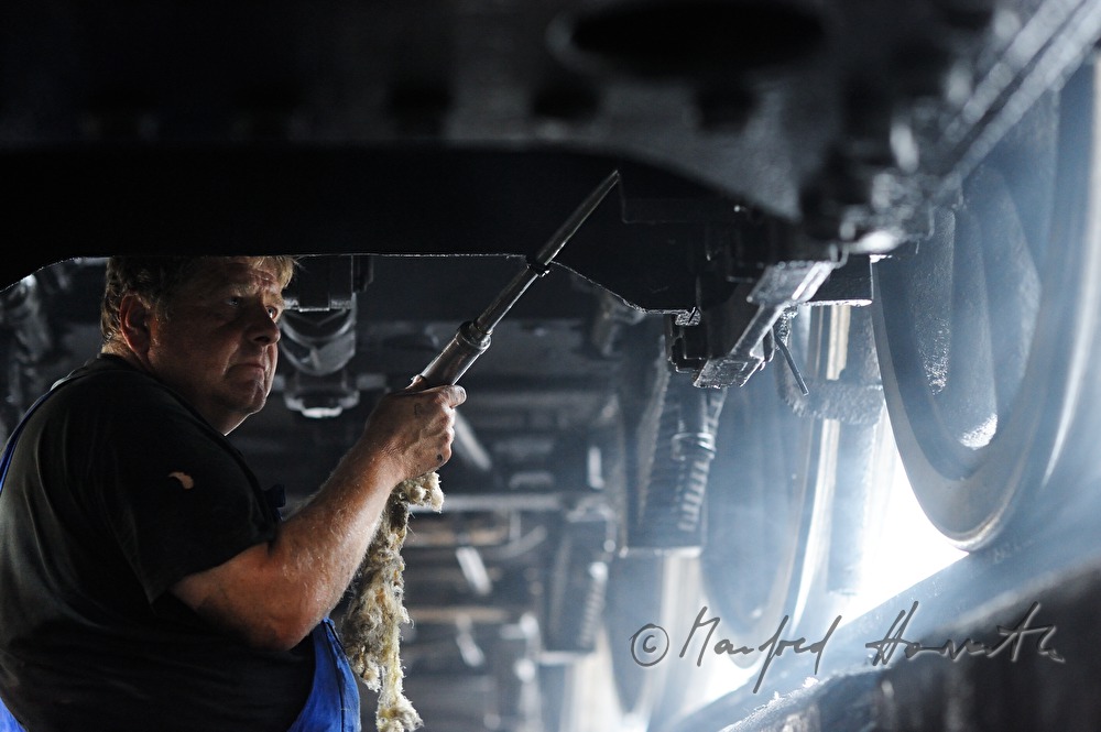 engine driver of the old locomotive 190.13 greasing the arbor