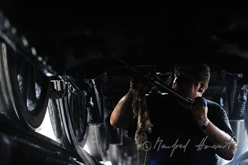 engine driver of the old locomotive 190.13 greasing the arbor