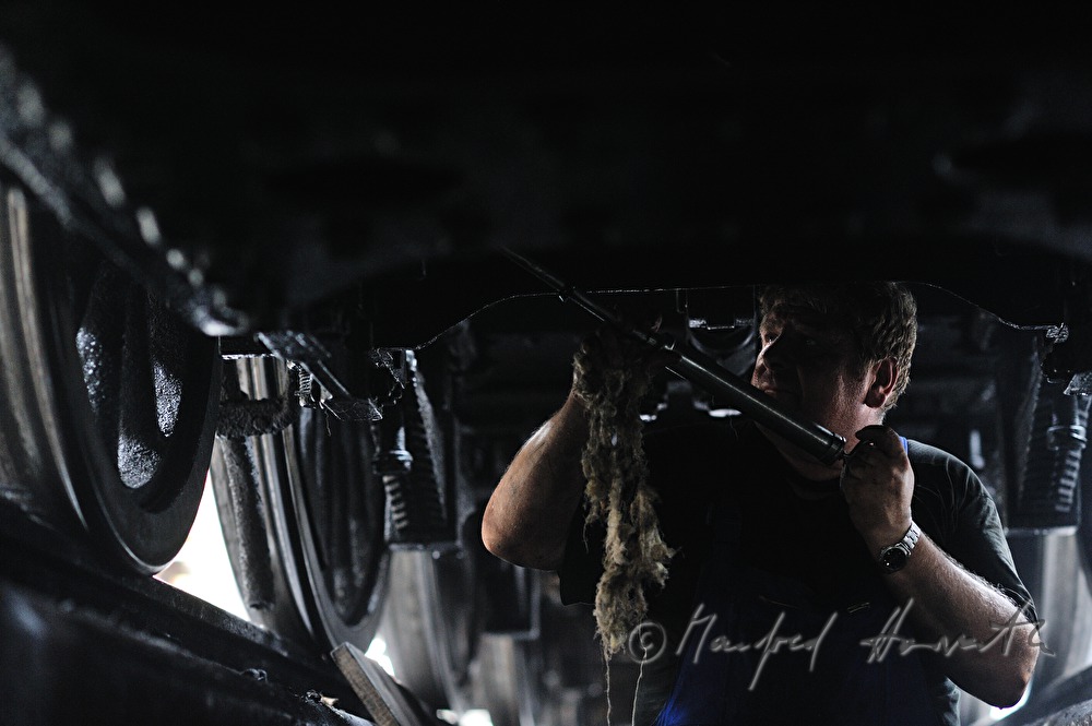 engine driver of the old locomotive 190.13 greasing the arbor