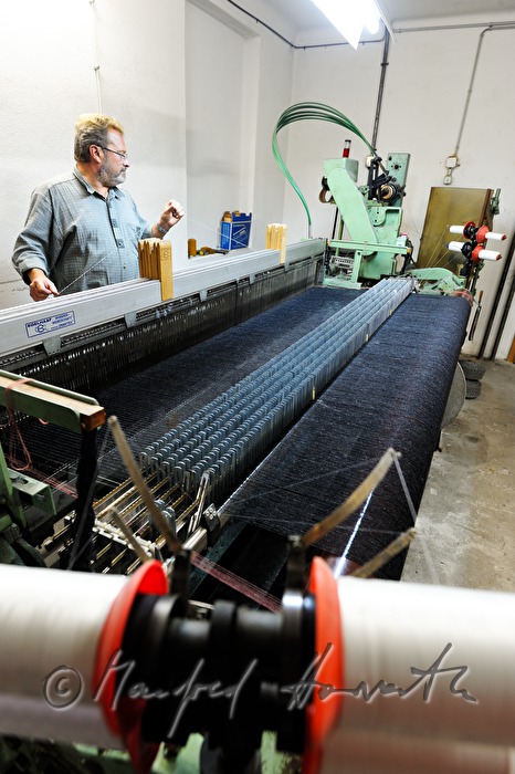worker changing coil at the loom