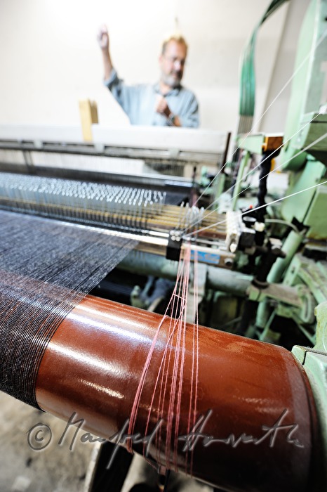 worker changing coil at the loom