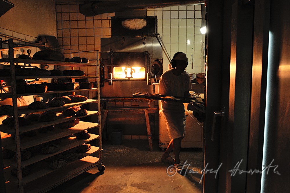 baker in his bakehouse with a stone oven