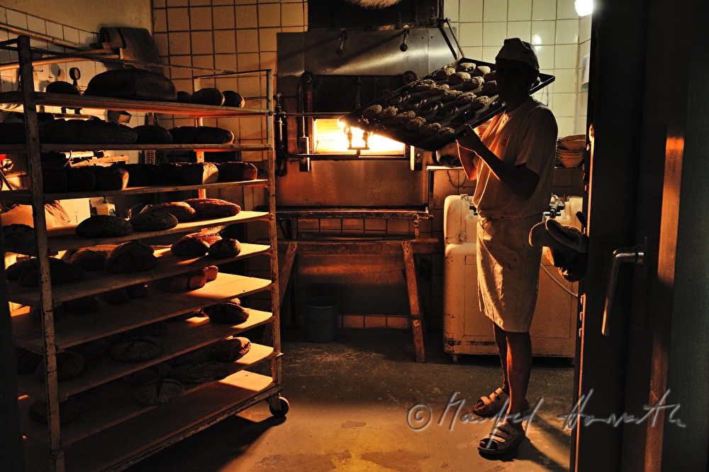 baker in his bakehouse with a stone oven