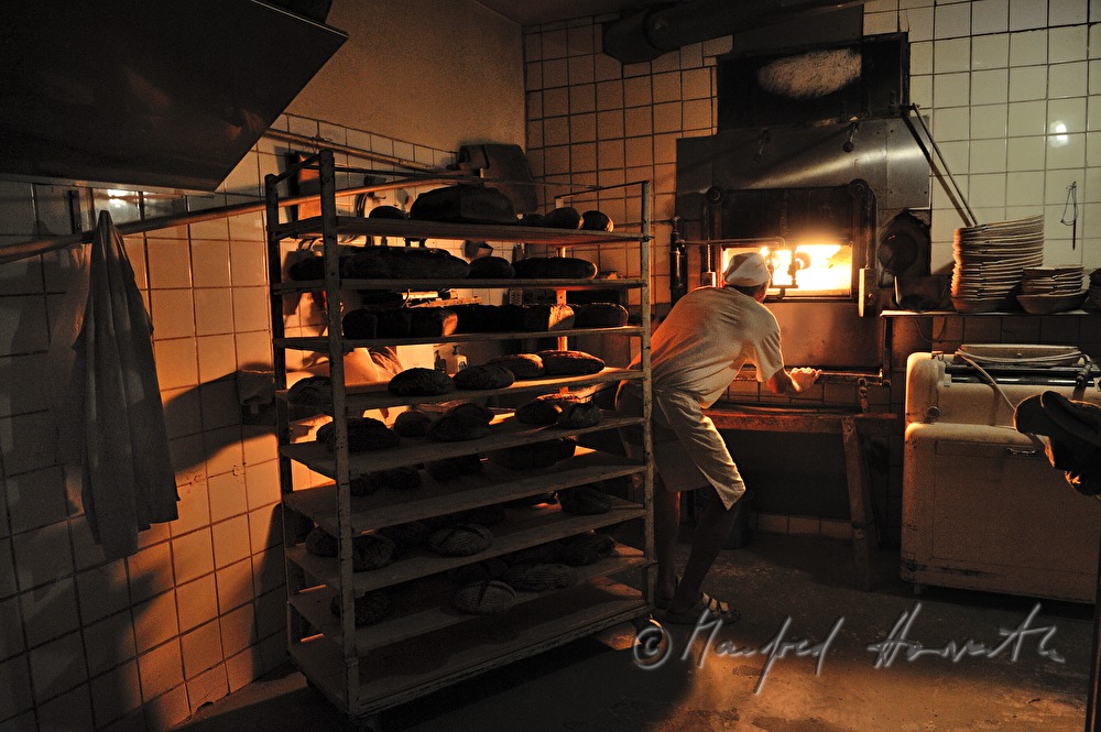 baker in his bakehouse with a stone oven