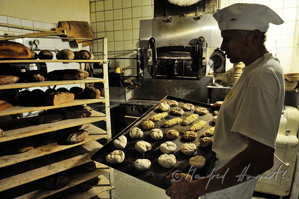 baker in his bakehouse with a baking tin