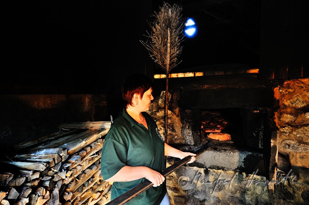 baking bread in the wood fired oven in the bakehouse