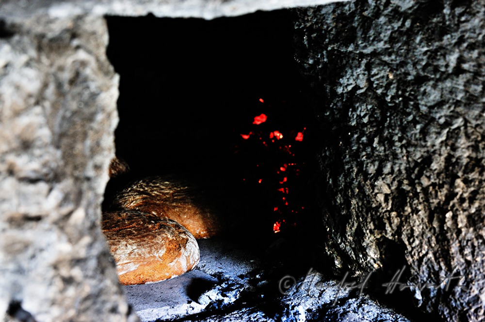 baking bread in the wood fired oven in the bakehouse