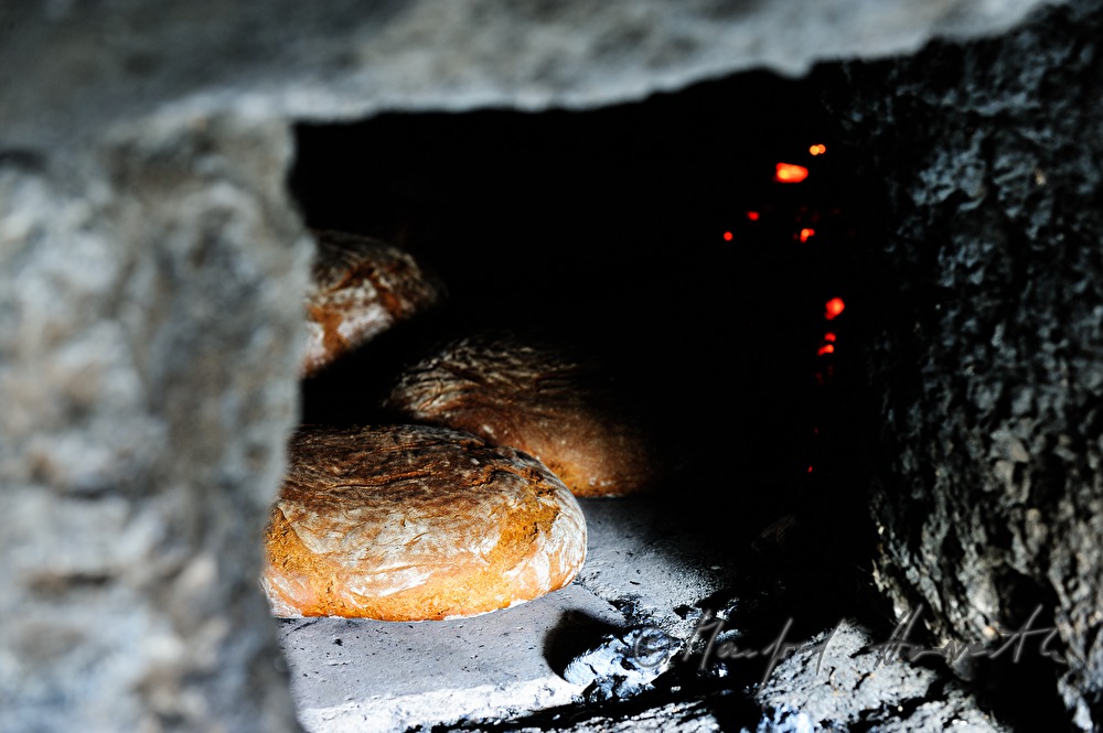 baking bread in the wood fired oven in the bakehouse