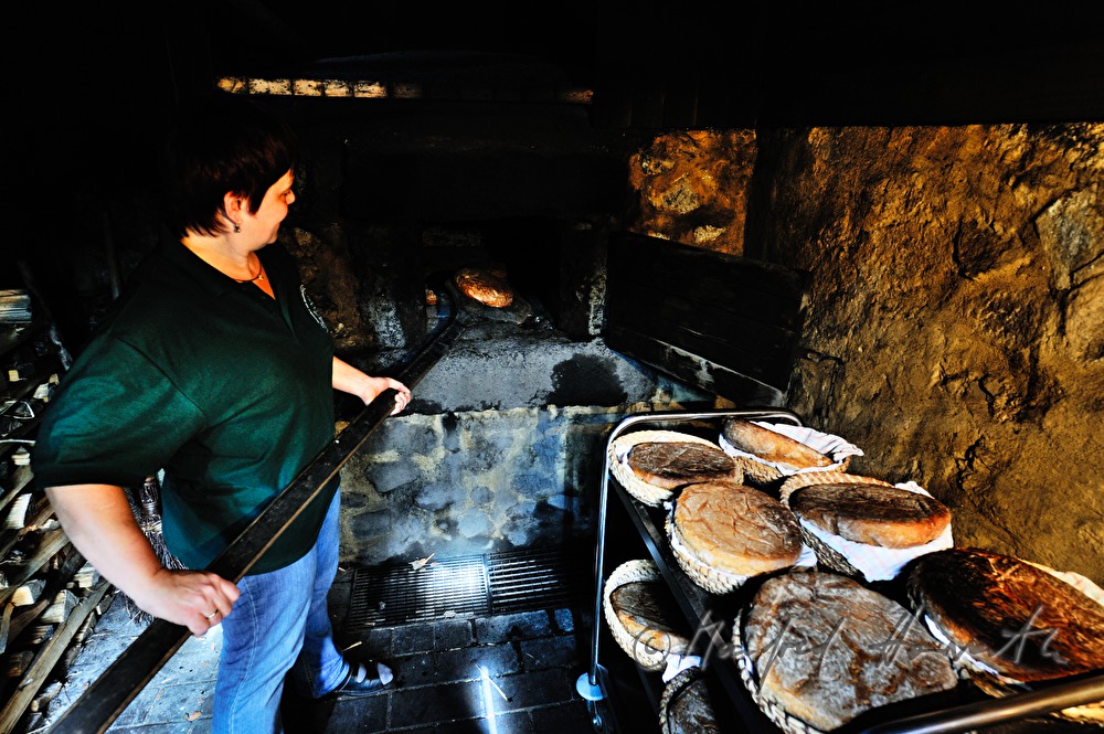 baking bread in the wood fired oven in the bakehouse