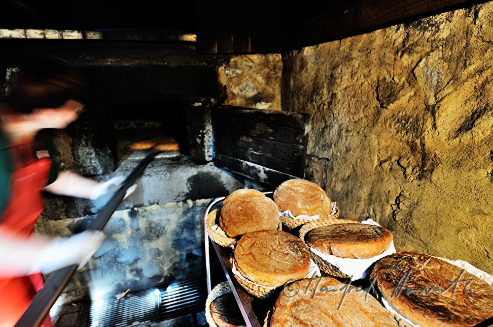 baking bread in the wood fired oven in the bakehouse