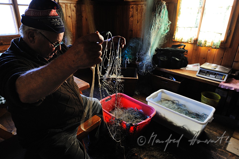 fisherman repairing nets in the fisherman's cottage