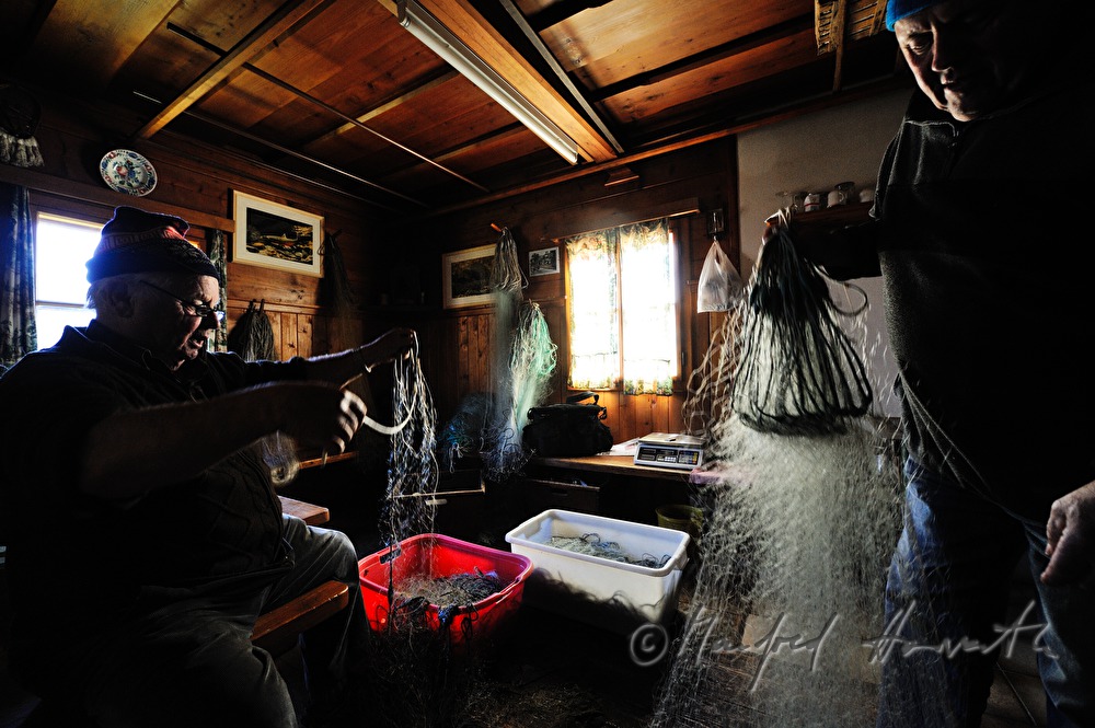 fisherman repairing nets in the fisherman's cottage
