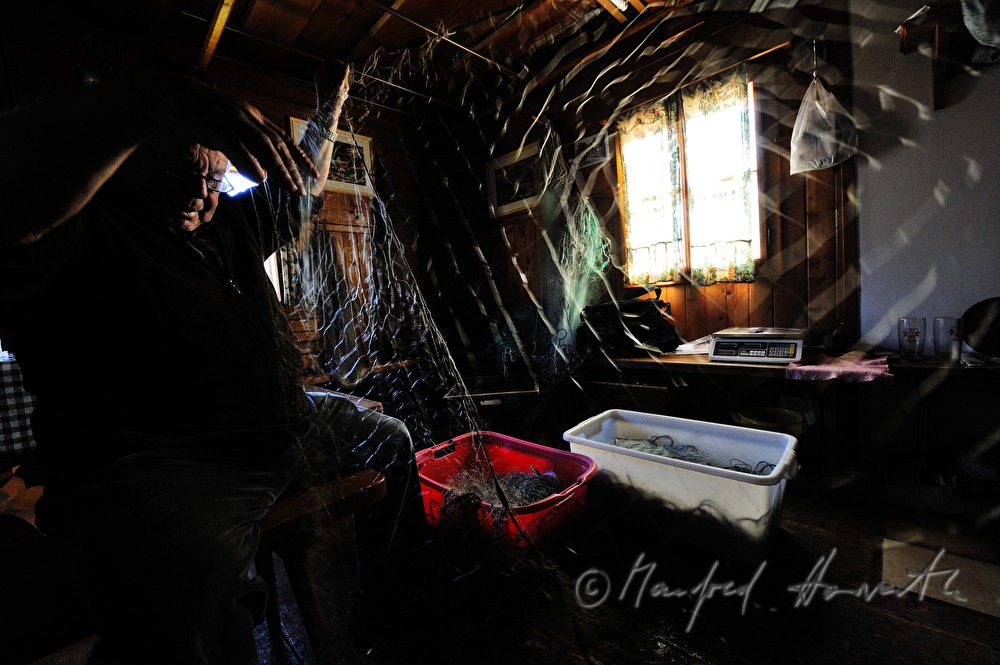 fisherman repairing nets in the fisherman's cottage