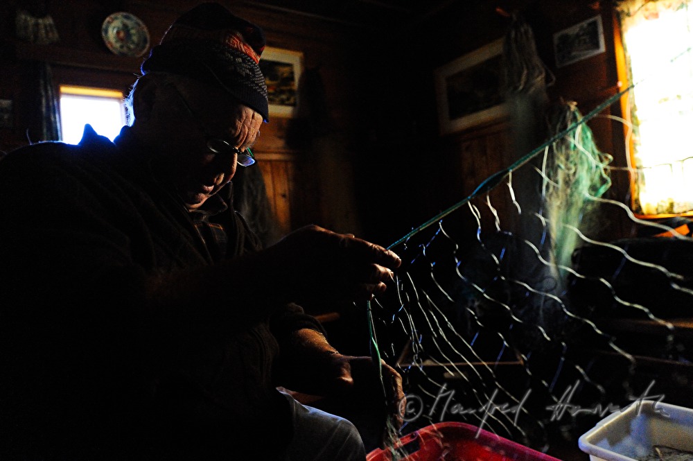 fisherman repairing nets in the fisherman's cottage