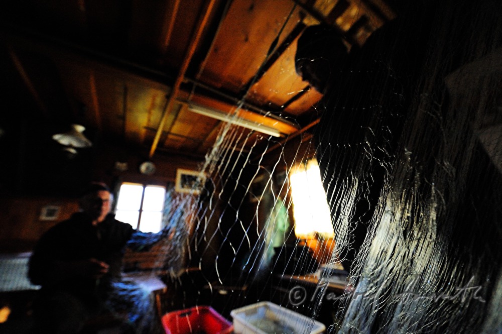 fisherman repairing nets in the fisherman's cottage