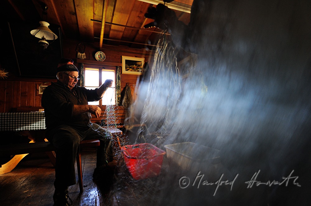 fisherman repairing nets in the fisherman's cottage