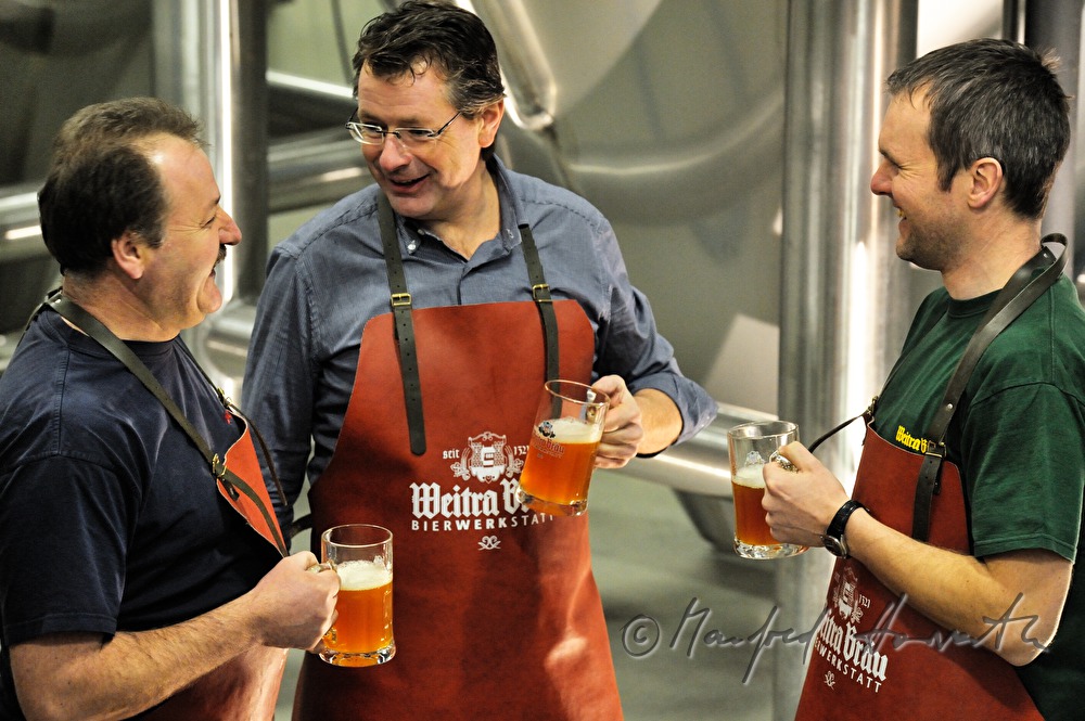 master brewer and workers tasting beer in the cellar