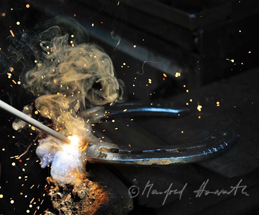 horseshoer welds a horseshoe at the mobile workstation