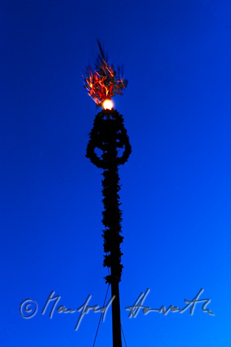 decorated maypole in evening illumination