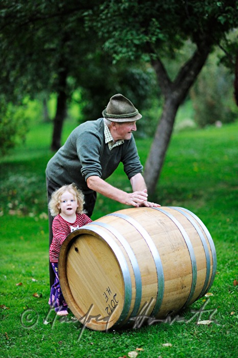 must farmer with grandchild rolling a barrel