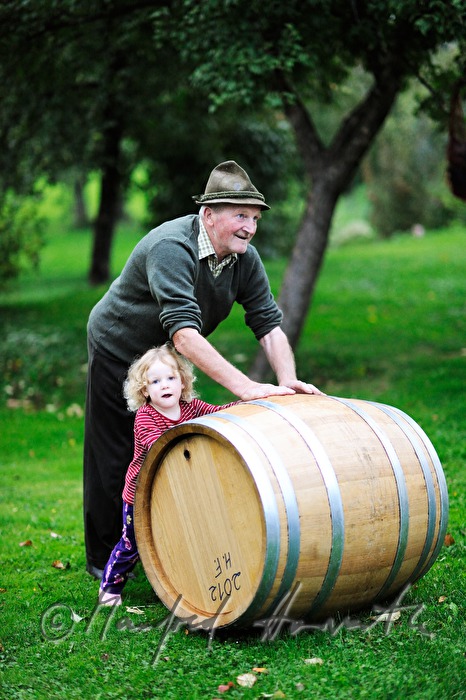 must farmer with grandchild rolling a barrel
