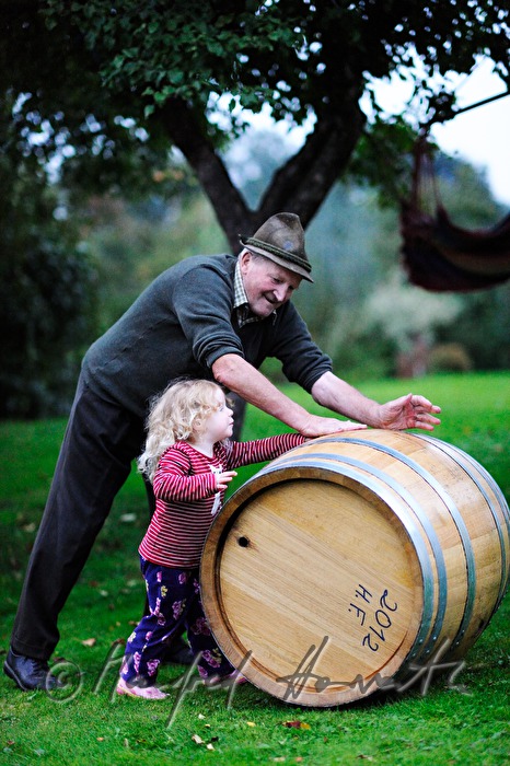 must farmer with grandchild rolling a barrel