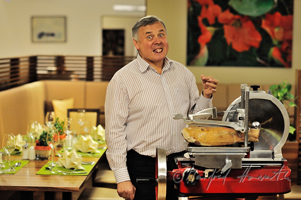 Alois Gölles slices Vulcano Ham in his restaurant