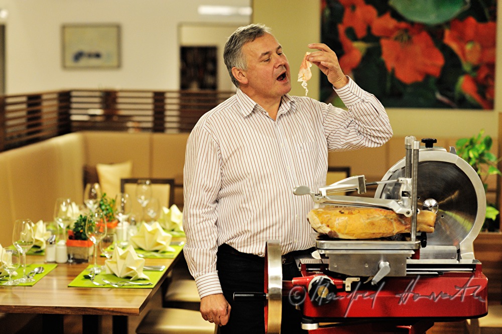 Alois Gölles slices Vulcano Ham in his restaurant
