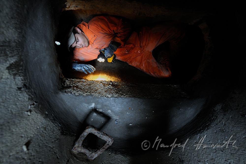 navvy in the manhole inspects the sewer