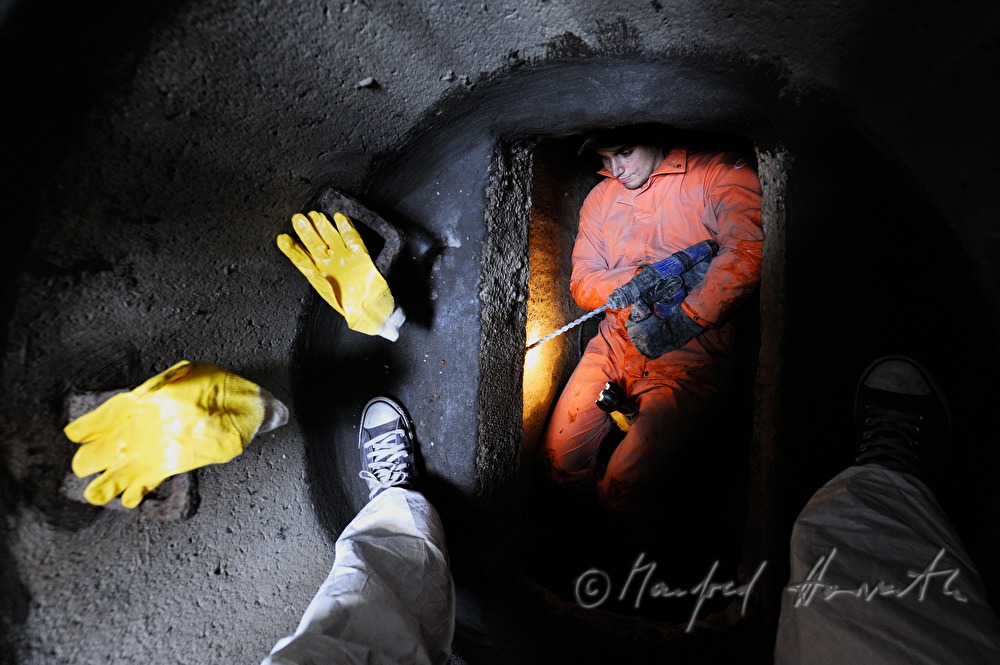 navvy in the manhole inspects the sewer