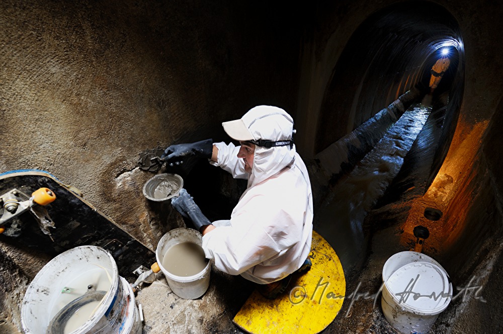 navvy in the manhole inspects the sewer