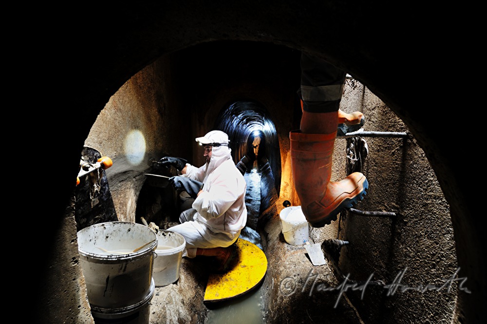 navvy in the manhole inspects the sewer