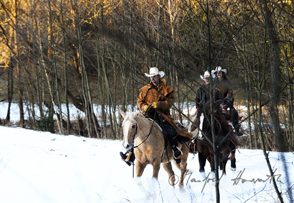 group of western riders near a stream