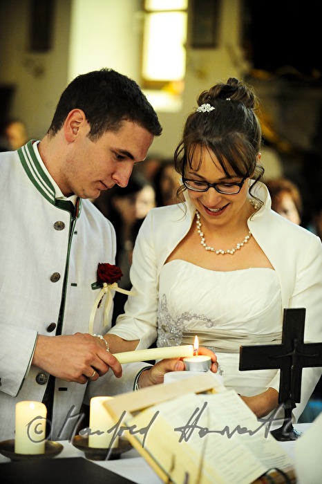 bride and groom lighting a candle