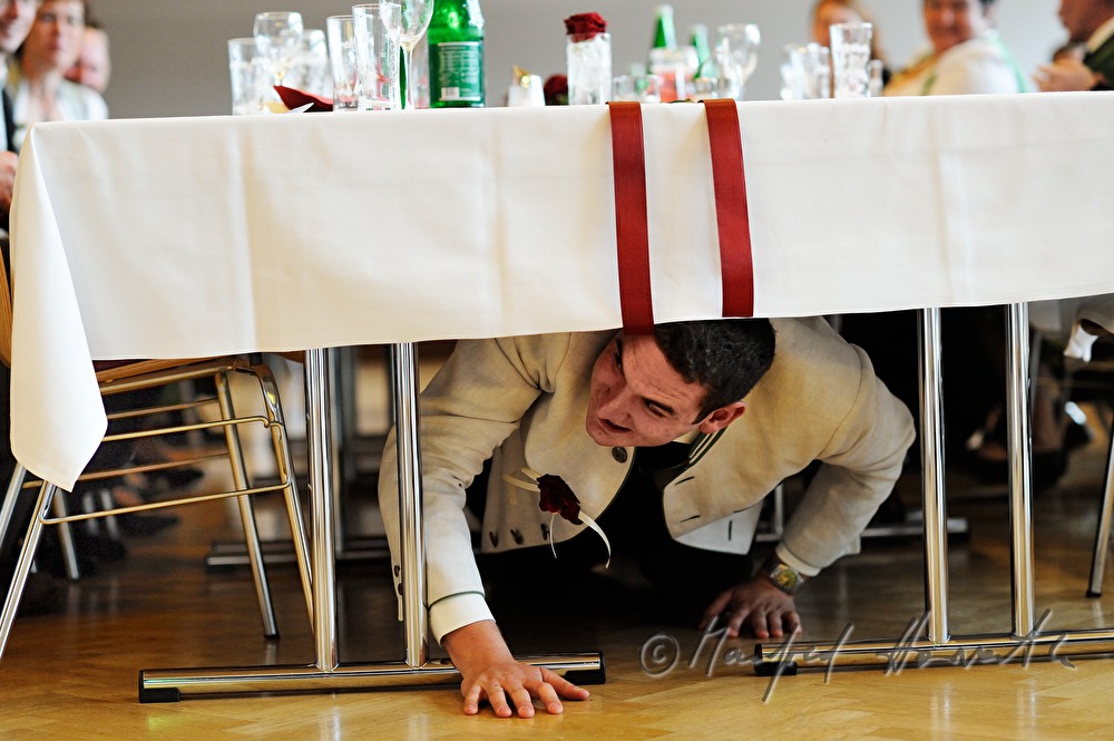 groom crawling under the table on the wedding party