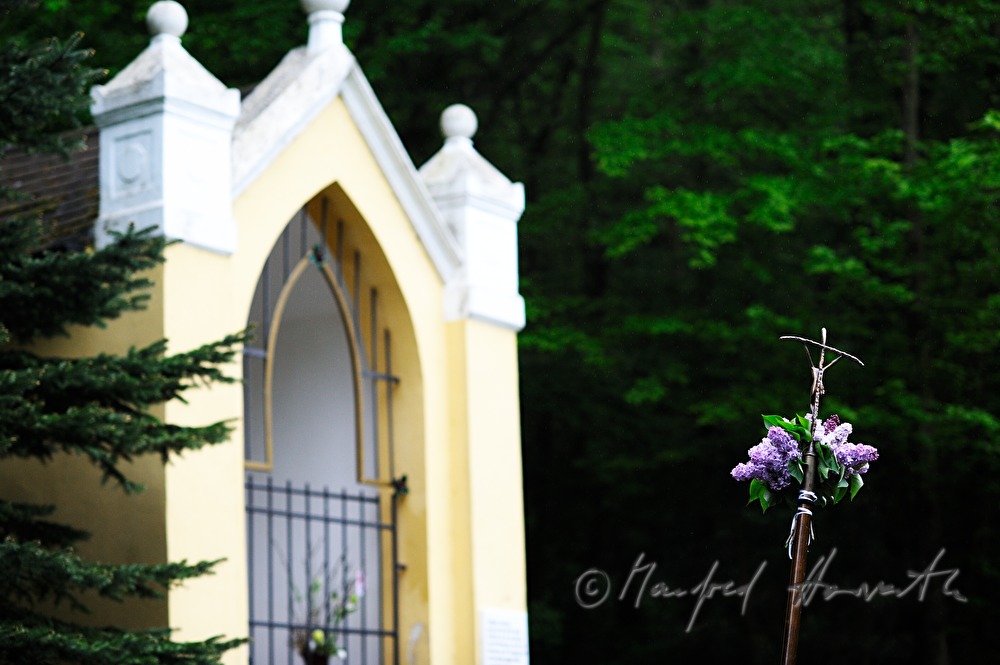 decorated crucifix near a chapel in the woods at a pilgrimage