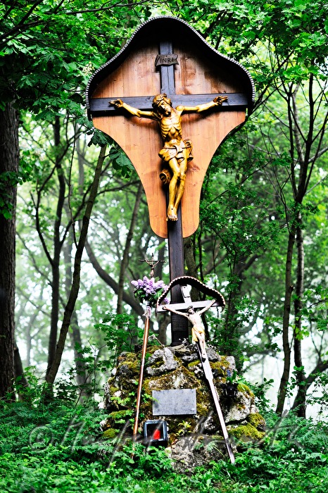 decorated crucifix near a chapel in the woods at a pilgrimage
