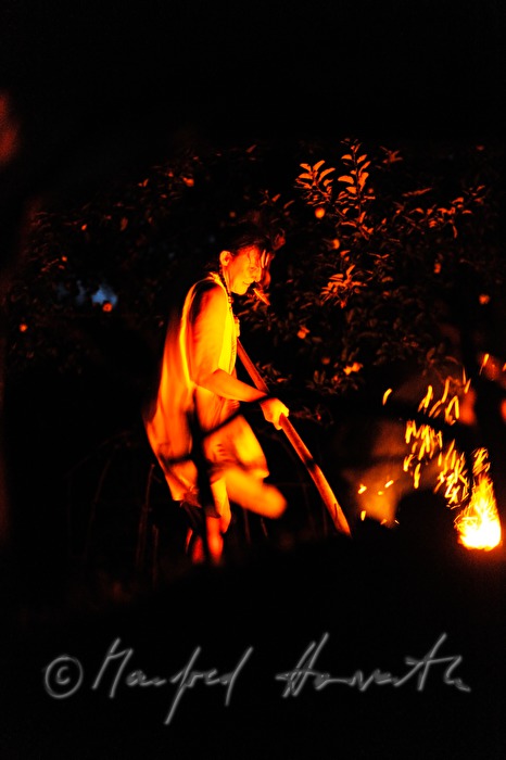 medicine woman taking hot stones from the fire
