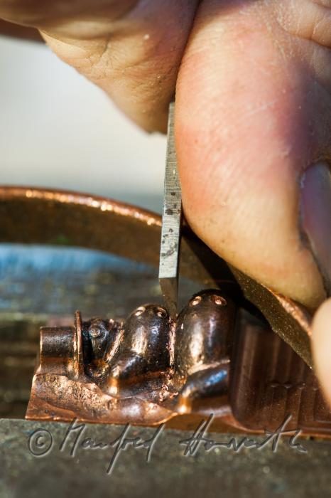 Erwin Perzy works on a snow man made of copper